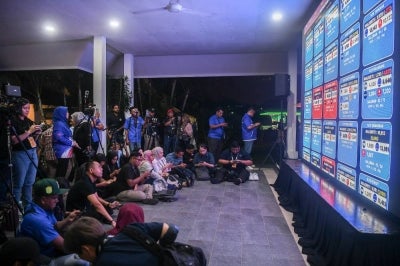 Media practitioners focus intently on the display of unofficial results for the 16th Johor state election at the Johor State Umno Liaison Building on July 11. BERNAMA photo