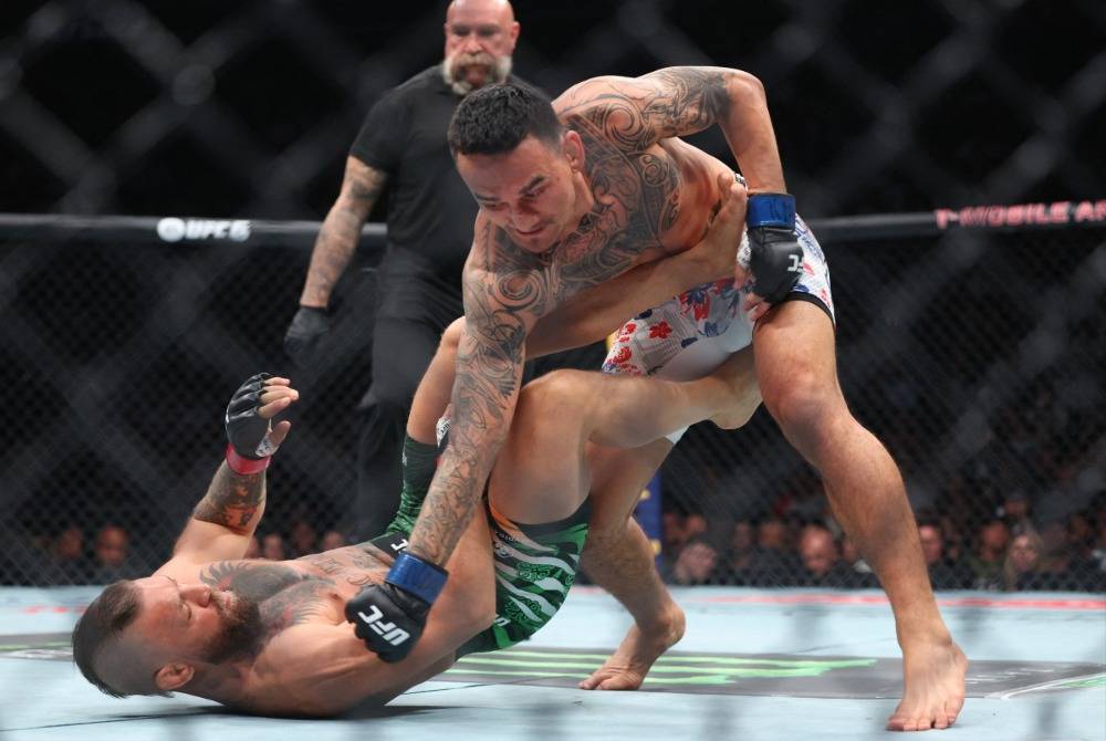 Max Holloway of the United States lands a punch on Conor McGregor of Ireland (Photo by Ian Maule / GETTY IMAGES NORTH AMERICA / Getty Images via AFP)