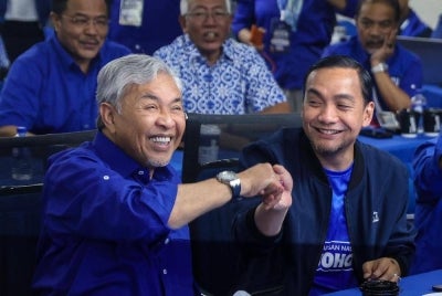 BN chairman Datuk Seri Ahmad Zahid Hamidi (left) shakes hands with Johor BN chairman Datuk Onn Hafiz Ghazi after unofficial results of the 16th Johor state election indicated a victory for BN, at the Johor Umno Liaison Committee headquarters in Johor Bahru, yesterday. - Photo by Bernama