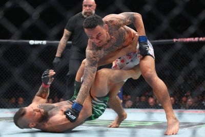 Max Holloway of the United States lands a punch on Conor McGregor of Ireland (Photo by Ian Maule / GETTY IMAGES NORTH AMERICA / Getty Images via AFP)