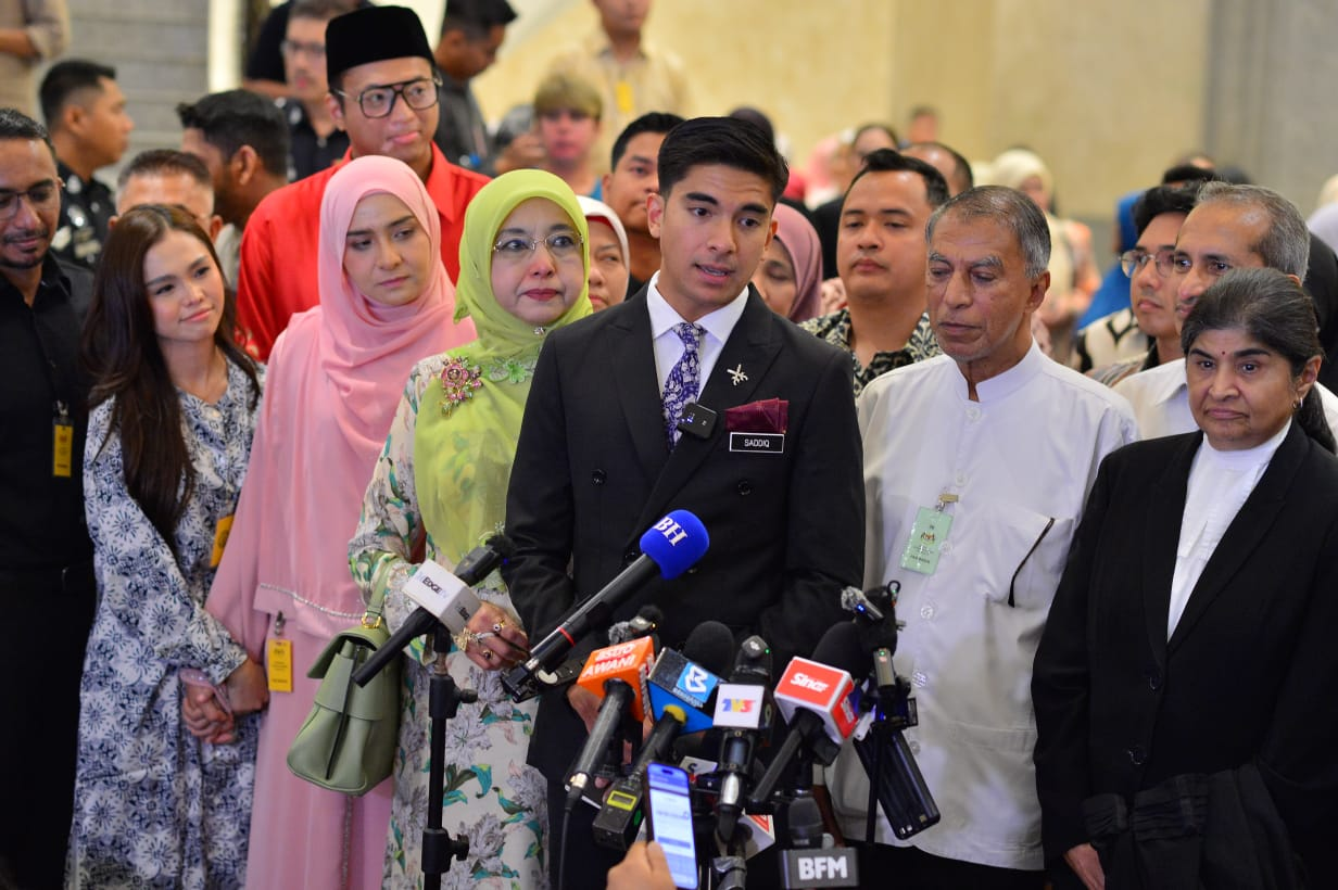 Syed Saddiq (centre) accompanied by his family, lawyers and fiancée Bella (most left, in blue-white baju kurung). (PHOTO BY ASRIL ASWANDI SHUKOR)