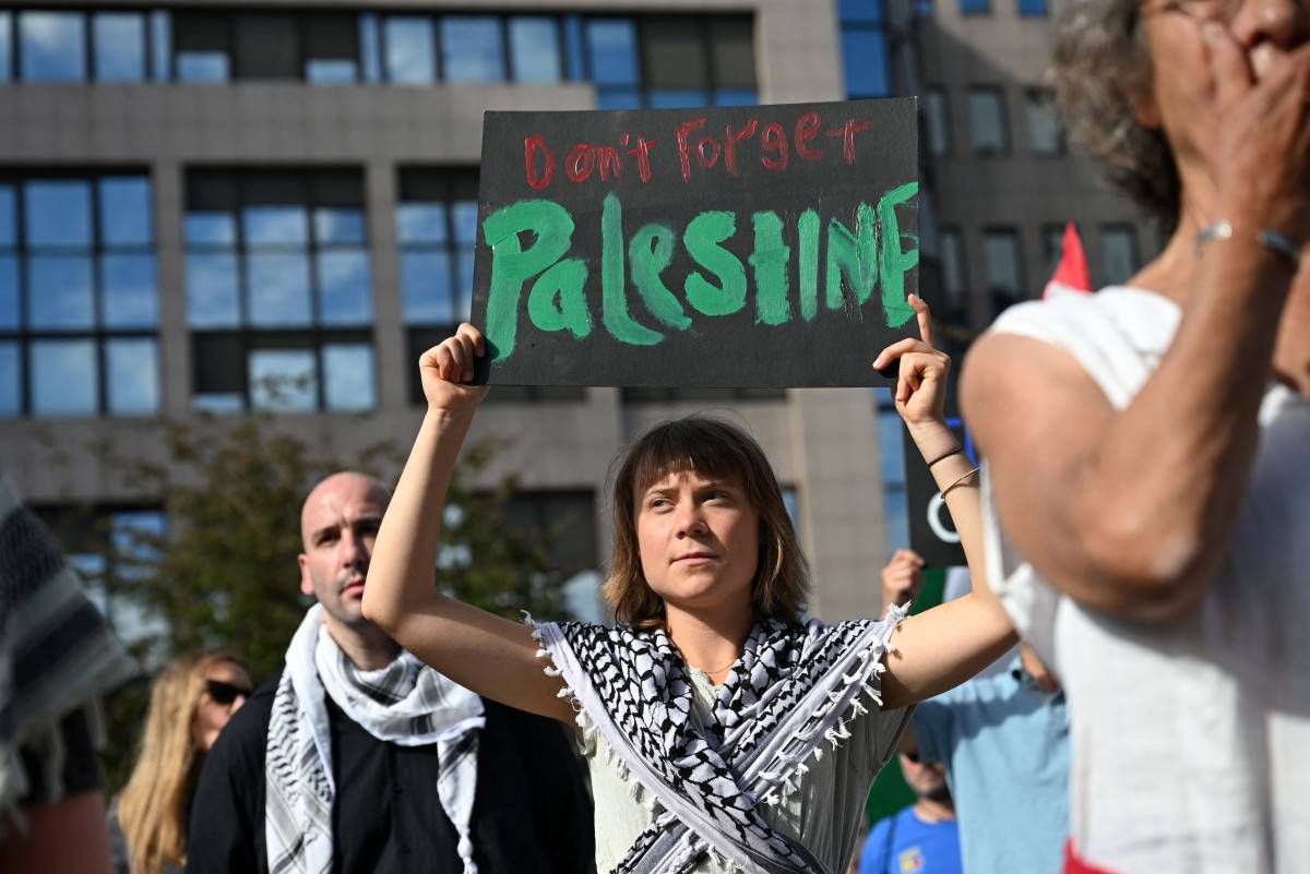 Swedish activist Greta Thunberg holds a placard reading "Don't forget Palestine" during a demonstration (Photo by Nicolas TUCAT / AFP)