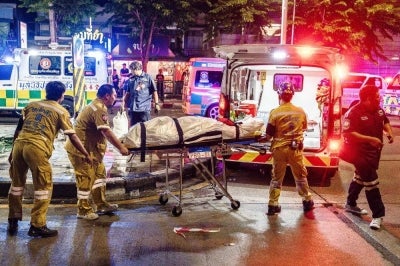 Emergency workers prepare to place the body of a victim into an ambulance after a fire at the Rong Beer Na Lat Phrao bar in Bangkok on July 13. Photo by AFP