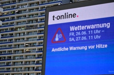 An information board displays a warning from extreme heat in Berlin, Germany (Photo by Tobias SCHWARZ / AFP)