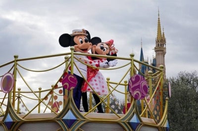 Performers dressed as Disney characters Minnie (R) and Mickey Mouse (L) wave to greet guests during a press preview for the theme park's new entertainment programme "Minnie, We Love You" at Tokyo Disneyland in Urayasu, Chiba. AFP file photo