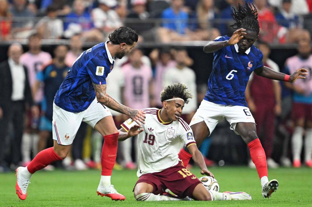 Spain's forward #19 Lamine Yamal (C) fights for the ball with France's defender #19 Theo Hernandez (L) and France's midfielder #06 Manu Kone during the 2026 World Cup football tournament semi-final match between France and Spain at the Dallas Stadium in Arlington. Photo by Mauro Pimentel/AFP