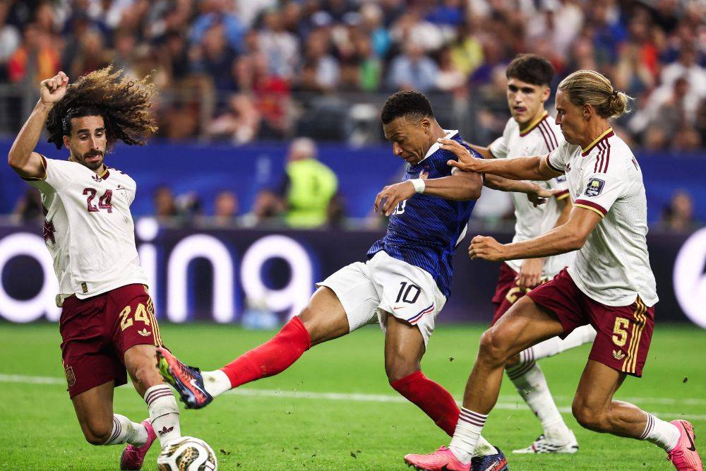 France's forward #10 Kylian Mbappe kicks the ball past Spain's defender #24 Marc Cucurella and midfielder #05 Marcos Llorente during the 2026 World Cup football tournament semi-final match between France and Spain. Photo by AFP