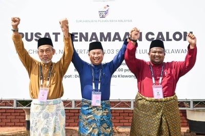Pakatan Harapan candidate for the N.04 Klawang state seat Bakri Sawir (left) alongside his challengers Muhammad Adib Musa (right) from Parti Pribumi Bersatu Malaysia (Bersatu) and Danni Rais representing Perikatan Nasional during the nomination process for the 16th Negeri Sembilan state election at the Dewan Besar Kuala Klawang Nomination Centre in Jelebu today. BERNAMA photo