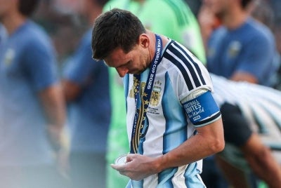 Argentina's forward #10 Lionel Messi looks at his second place medal after losing the 2026 World Cup football tournament final match between Spain and Argentina at the New York/New Jersey Stadium in East Rutherford on July 19, 2026. - (Photo by PATRICIA DE MELO MOREIRA / AFP)