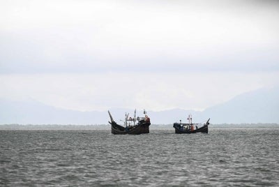 This photograph taken on June 21, 2026 shows fishing boats sailing along the Naf River, frequently used by traffickers to transport Rohingya refugees, near Teknaf in Bangladesh's Cox's Bazar. - (Photo by MUNIR UZ ZAMAN / AFP)