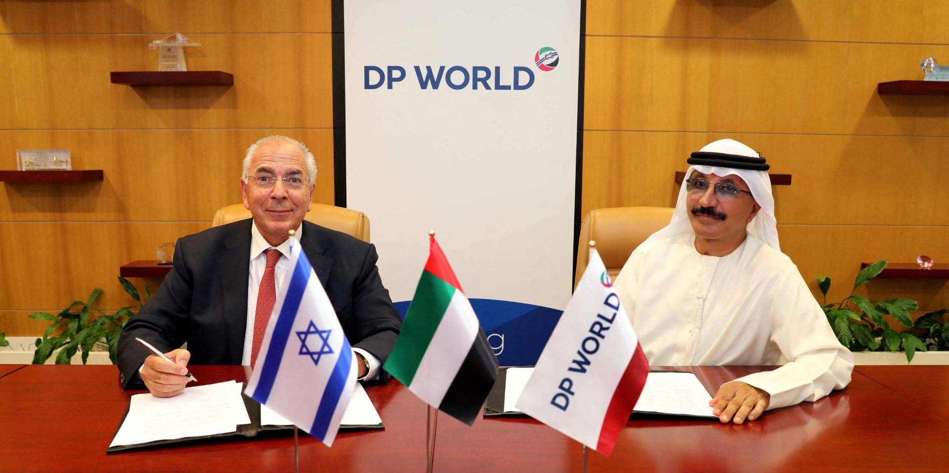 A handout picture released by DP World, the Dubai-based ports operator, on September 16, 2020 shows the group's Chairman and CEO, Sultan Ahmed bin Sulayem (R), and Shlomi Fogel, the owner of DoverTower, the co-owner of Israel Shipyards and Port of Eilat, signing an agreement in Dubai. (Photo by DP WORLD / AFP) 