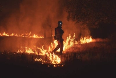 This handout photo released on July 23, 2026 and taken on July 22, 2026 by Spain's Military Emergencies Unit (UME) shows UME personnel fighting a wildfire near Almorox, 70 kilometers southwest of Madrid. - (Photo by Handout / UME / AFP)