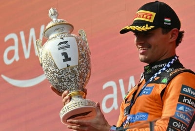 Lando Norris lifts the Hungarian GP trophy (\Photo by Andrej ISAKOVIC / AFP)