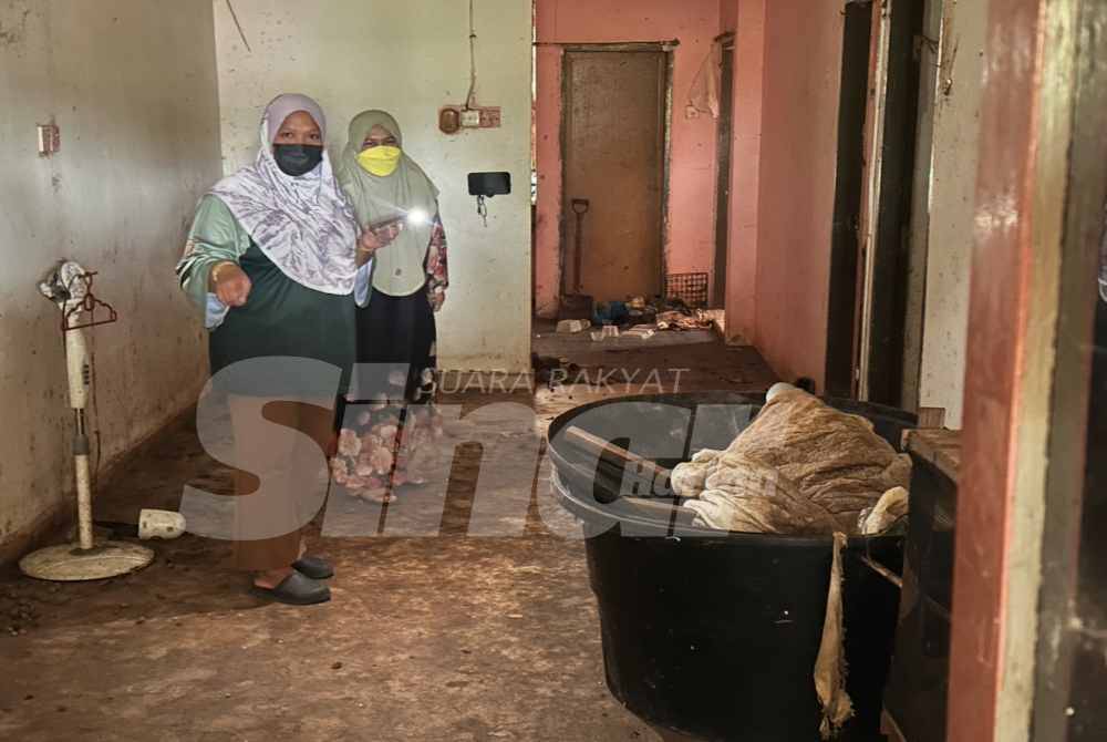 Nurul Farhana Saeidi (left) inspects the filthy and foul-smelling condition of her house.