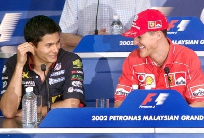 Ferrari's ace driver Formula One World Champion Michael Schumacher (R), from Germany, chats with hometown favorite Minardi's Alex Yoong, from Malaysia. - (Photo by STEPHEN SHAVER / AFP)