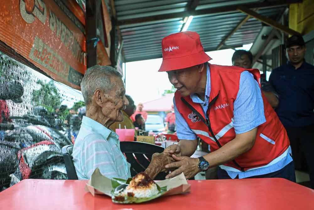 Pakatan Harapan (PH) candidate for the N.32 Linggi State Legislative Assembly Datuk Seri Aminuddin Harun (right), engaging with members of the public during a campaign visit at Warung Sulaiman. - Photo by Bernama