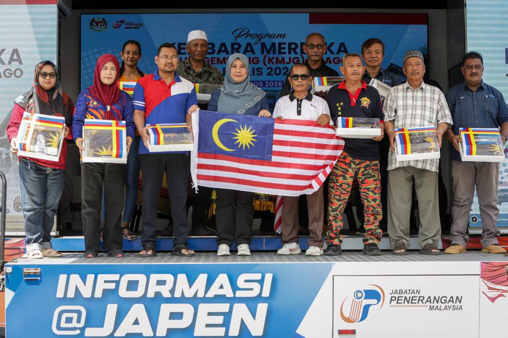 Perlis State Information Department director Aidatul Shima Che Hassan (centre) poses with representatives of the Arau Parliamentary Constituency MADANI Community after presenting the Jalur Gemilang Kit during the Perlis State Level Kembara Merdeka Jalur Gemilang X JAPEN Arena Penggerak Komuniti (JAGO) Programme in conjunction with the National Month and Fly the Jalur Gemilang 2026 campaign at Kampung Pauh Setia, Pauh today. BERNAMA photo