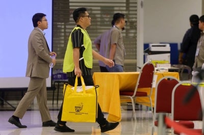 Election Commission officials transport ballot boxes to the Official Vote-Tallying Centre for the Lenggeng, Nilai, Lobak, Temiang, Sikamat and Ampangan State Legislative Assembly constituencies during the 16th Negeri Sembilan polls at Dewan Majlis Bandaraya Seremban today. - Photo by Bernama