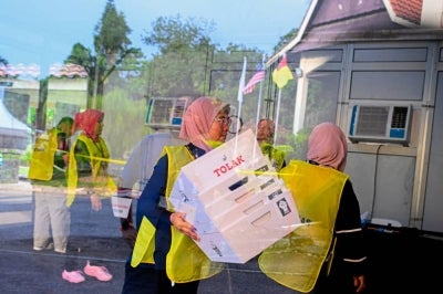 Election Commission personnel pack up equipment after the voting process ended at 6pm during the 16th Negeri Sembilan polls at the Pejabat RISDA Daerah Rahang polling centre today. - Photo by Bernama