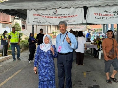 Datuk Seri Mohamad Hasan and his wife Datin Seri Raja Salbiah Tengku Najumuddin at the SJKC Chung Hua on Aug 1. They arrived at the polling centre for Rantau at around 8.30am. (Photo by Safwan Saidon) 