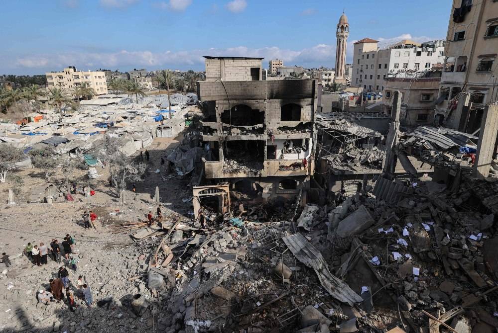 Palestinians inspect the rubble at the site of a residential building targeted overnight by an Israeli strike in Deir el-Balah in the central Gaza Strip. AFP photo.