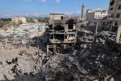 Palestinians inspect the rubble at the site of a residential building targeted overnight by an Israeli strike in Deir el-Balah in the central Gaza Strip. AFP photo.