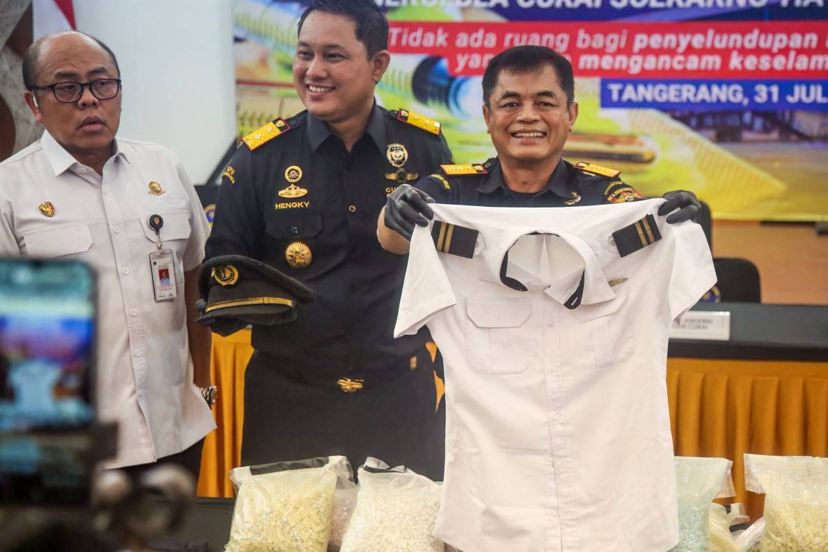 Indonesian Customs officials display the uniform of a Malaysian pilot and drugs he smuggled as evidence during a press conference at Soekarno-Hatta International Airport in Tangerang on July 31. Photo by AFP