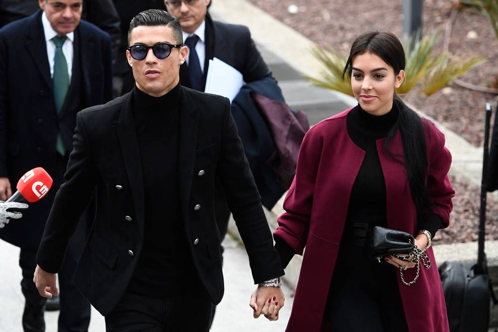 Juventus' forward and former Real Madrid player Cristiano Ronaldo (L) arrives with his Spanish girlfriend Georgina Rodriguez (R) to attend a court hearing for tax evasion in Madrid on Jan 22, 2019. - (Photo by PIERRE-PHILIPPE MARCOU / AFP)