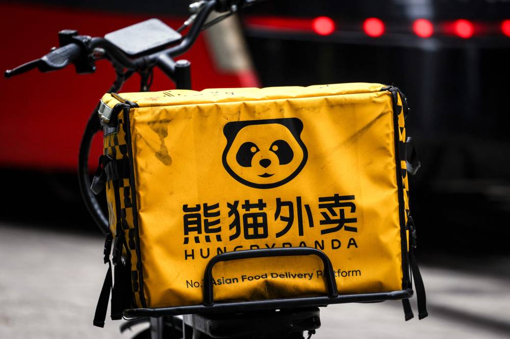 A HungryPanda food delivery electric bike sits on a footpath in central Sydney on February 19, 2026. Hundreds of thousands of gig workers in Australia have been granted a huge pay rise from August 17, 2026 under a decision by the country's workplace relations tribunal lauded as "world-leading". (Photo by DAVID GRAY / AFP)