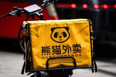 A HungryPanda food delivery electric bike sits on a footpath in central Sydney on February 19, 2026. Hundreds of thousands of gig workers in Australia have been granted a huge pay rise from August 17, 2026 under a decision by the country's workplace relations tribunal lauded as "world-leading". (Photo by DAVID GRAY / AFP)