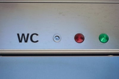 The lettering WC and red and green indicator lights showing whether the cubicle is occupied are pictured on one of the public toilets in the Augarten, a historic Baroque park in Vienna, Austria. A Viennese woman is suing the city council for discrimination over access to public toilets, complaining that women must pay to use cubicles while men can use urinals for free. (Photo by PATRICK SIEBER / AFP)
