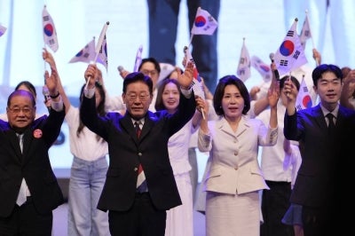 South Korean President Lee Jae Myung (centre L) and his wife Kim Hea Kyung (centre R) wave the national flags during a ceremony to celebrate the 81st anniversary of the Korean Liberation Day in Seoul on August 15, 2026. (Photo by Lee Jin-man / POOL / AFP)