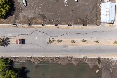 This aerial photo shows cracks in a road in Marapokot, Nagekeo, East Nusa Tenggara, on Aug 17, 2026, following a 7.7-magnitude earthquake. - (Photo by JUNI KRISWANTO / AFP)