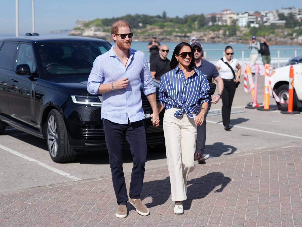 Britain's Prince Harry, Duke of Sussex, and his wife Meghan, the Duchess of Sussex, arrive to meet with volunteer first responders from Bondi Surf Bathers' Life Saving Club at Bondi Beach in Sydney on April 17, 2026. - (Photo by Jonathan Brady / POOL / AFP)