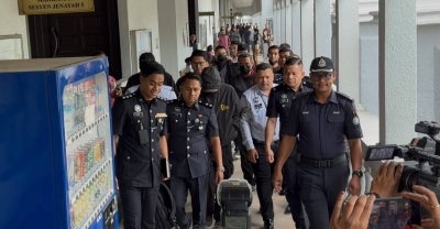 Immigration Department ‘Black Maria’ lorry driver Mohd Akbar Zainol, 43, was charged today with five offences, including dangerous driving that resulted in the deaths of a father and his two daughters yesterday.