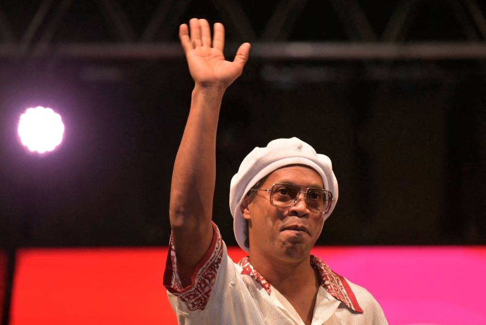 Newly recruited Brazilian football player Ronaldinho waves to fans from the stage during the Ravenna FC team presentation in Marina di Ravenna on August 20, 2026. Former Ballon d'Or and World Cup winner Ronaldinho is set to come out of retirement aged 46 to play for Ravenna in the Italian third tier. - (Photo by Stefano RELLANDINI / AFP)