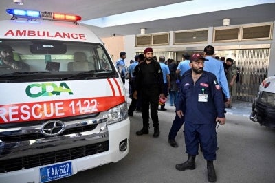 Security personnel stand next to an ambulance following a fire incident outside the Mother and Child Health (MCH) ward at the Pakistan Institute of Medical Sciences (PIMS) Hospital in Islamabad. Photo by AFP
