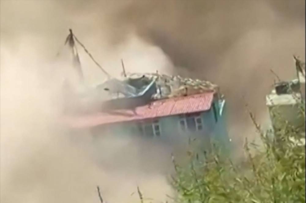 This frame grab from a UGC footage courtesy of Nepal Police shows floodwaters sweeping through houses along the Bhote Koshi River in Rasuwa district after flash floods. Photo by - UGC/Nepal Police/AFP