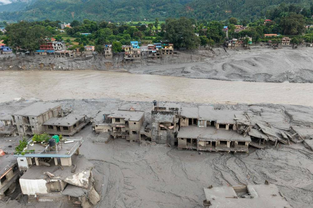 An aerial view shows houses lying deluged in sludge after flash floods at Devighat, Bidur Municipality in Nepal's Nuwakot district on Aug 27, 2026. - (Photo by PRABIN RANABHAT / AFP)