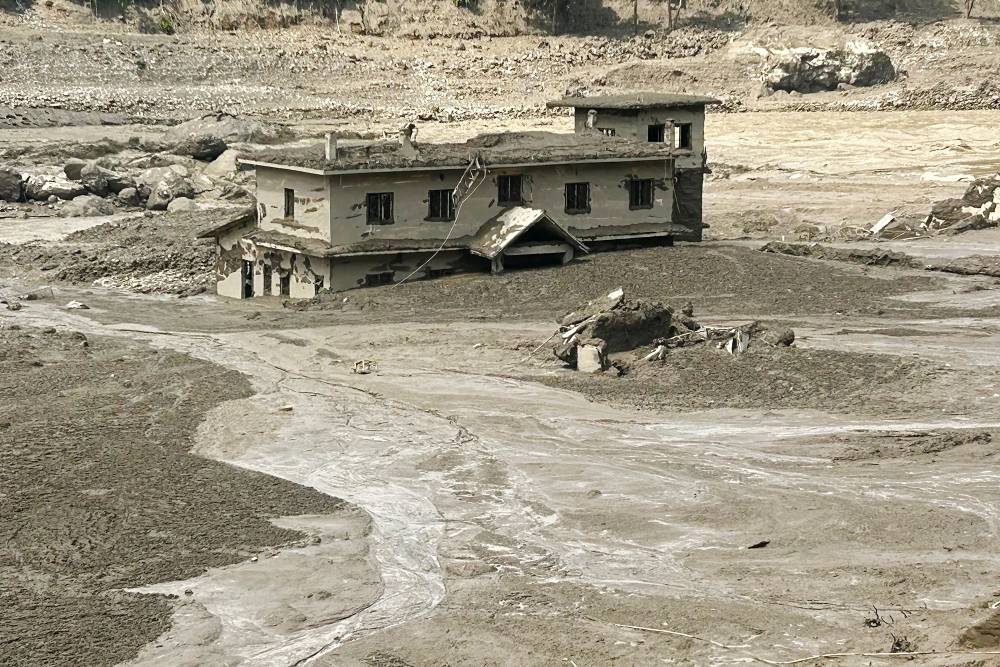 A house lies partially submerged in muddy water after flash floods at Trishuli Bazar in Nepal's Nuwakot district on Aug 26, 2026. - (Photo by PRAKASH MATHEMA / AFP)