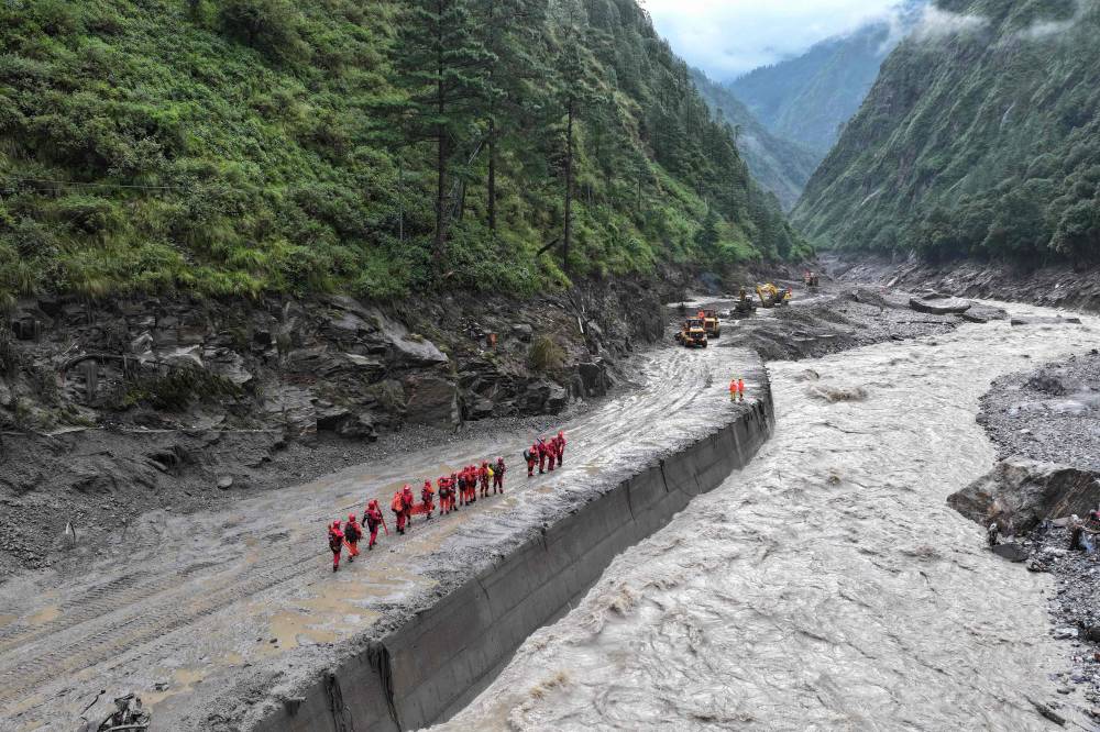 Fire and rescue personnel conduct search and rescue operations on a section of a road leading to Gyirong Port which was damaged after a mudslide two days earlier, in Gyirong County, in China痴 western Tibet region on Aug 28, 2026. -(Photo by CNS / AFP)