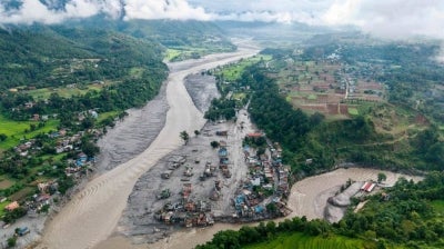 An aerial view shows houses lying deluged in sludge after flash floods at Devighat, Bidur Municipality, along the confluence of the Trishuli and Tadi rivers in Nepal's Nuwakot district on Aug 27, 2026. - (Photo by PRABIN RANABHAT / AFP)