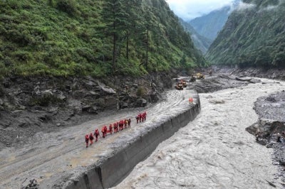 Fire and rescue personnel conduct search and rescue operations on a section of a road leading to Gyirong Port which was damaged after a mudslide two days earlier, in Gyirong County, in China痴 western Tibet region on Aug 28, 2026. -(Photo by CNS / AFP)