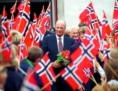 Picture taken on June 24, 1998 shows King Harald V of Norway surrounded by Norwegian flags as he visits Farsund, South-West Norway. Norway's King Harald V, Europe's oldest reigning monarch, died on August 28,2026 at the age of 89, the royal palace announced. (Photo by Terje Bendiksby / AFP)