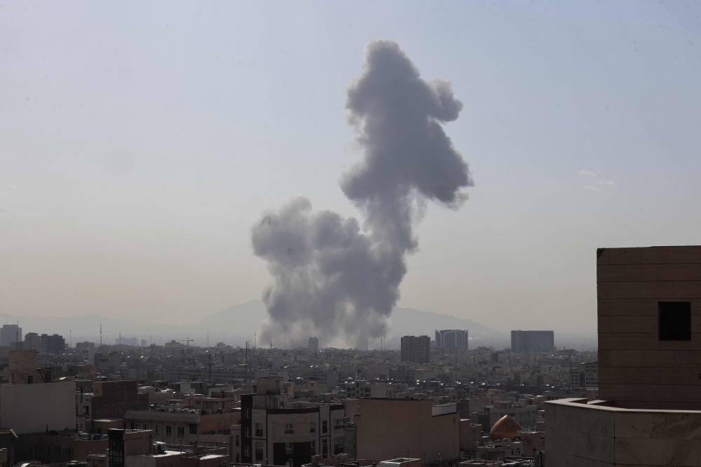 A plume of smoke rises following a reported explosion in Tehran on Feb 28, 2026. On Feb 28, the United States and Israel launched a massive offensive against Iran, igniting a war that swiftly engulfed the region and hit global energy markets. - (Photo by ATTA KENARE / AFP)