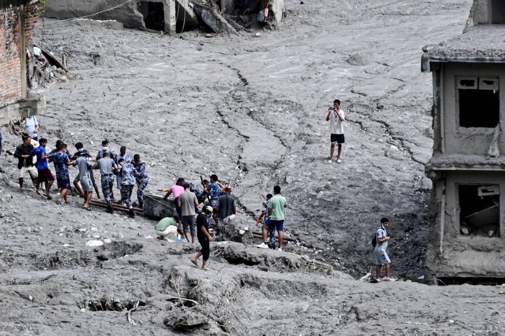 Rescue personnel pull out a locker from a deluged bank after flash floods at Trishuli Center in Nepal's Nuwakot district on Sept 1, 2026. - (Photo by ARUN SANKAR / AFP)
