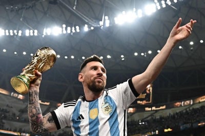 Argentina's captain and forward #10 Lionel Messi pose with the FIFA World Cup Trophy after Argentina won the Qatar 2022 World Cup final football match between Argentina and France at Lusail Stadium in Lusail, north of Doha on Dec 18, 2022. - (Photo by Anne-Christine Poujoulat / AFP)