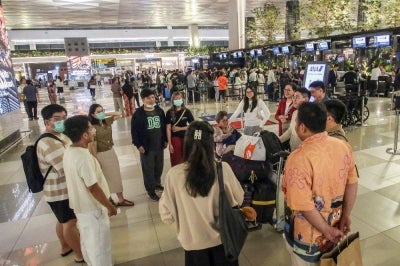 Stranded passengers gather as they wait at Soekarno-Hatta Airport in Tangerang. Photo by AFP