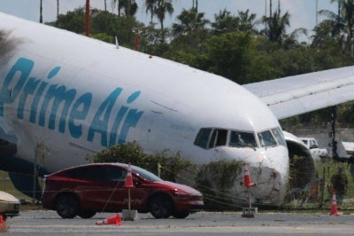 Investigators continue work to determine what caused the crash of an Amazon cargo plane at Miami International Airport. Photo by AFP