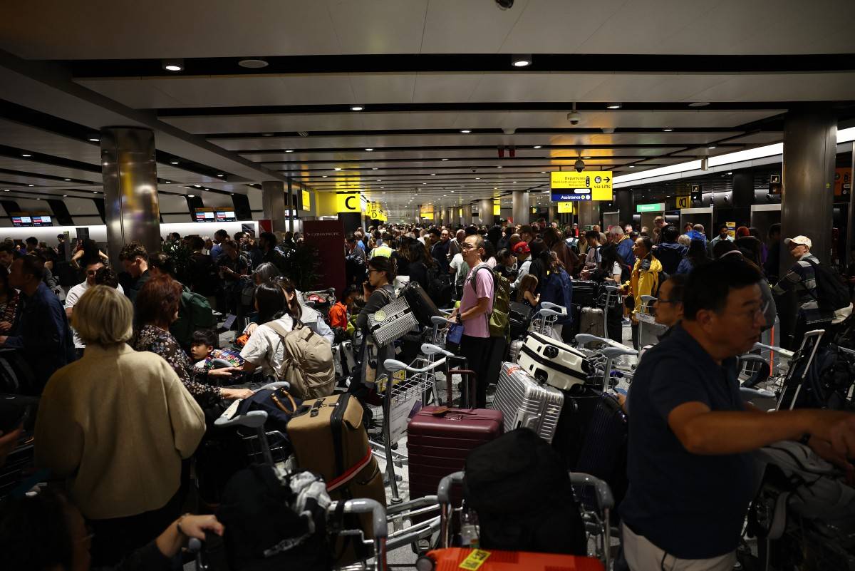 Delayed passengers wait and queue with their luggage at Terminal 3 of London Heathrow airport, west of London on Sept 8, 2026, following major disruption due an issue affecting the NATS air traffic control systems. - (Photo by HENRY NICHOLLS / AFP)